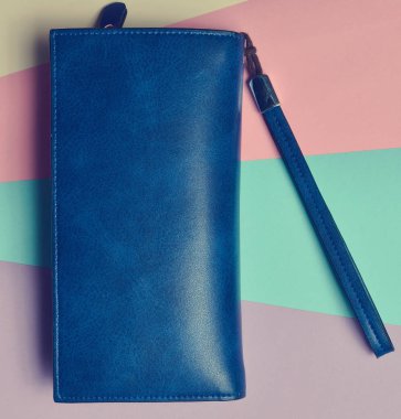 Pastel renkli arka plan üzerinde büyük bir mavi çanta. Minimalizm eğilimini. Üstten görünüm.