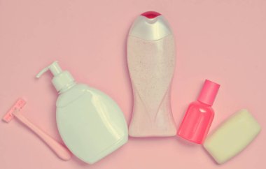 Bir şişe kokulu parfüm, losyon, şampuan, sabun, ustura. Vücut, saç ve pastel pembe bir arka plan üzerinde kişisel hijyen ve bakım ürünleri. Üstten görünüm. Minimalizm eğilimini. Düz yatıyordu.
