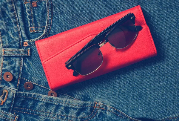 女人的东西和配件 经典太阳镜 红色皮包 牛仔裤 — 图库照片