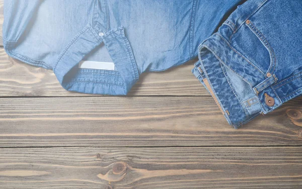 木制表面上的牛仔裤 裤子和牛仔裤衬衫 顶视图 — 图库照片