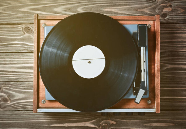 Vinyl player with plates on a wooden table. Entertainment 70s. Listen to music. Top view.