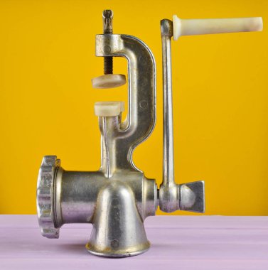 Pastel sarı bir arka plan üzerinde Vintage kıyma makinesi. Minimalizm eğilim