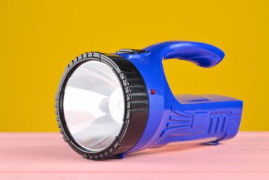 Mavi el feneri projektör sarı wal üzerinde izole bir masa üzerine yatıyor