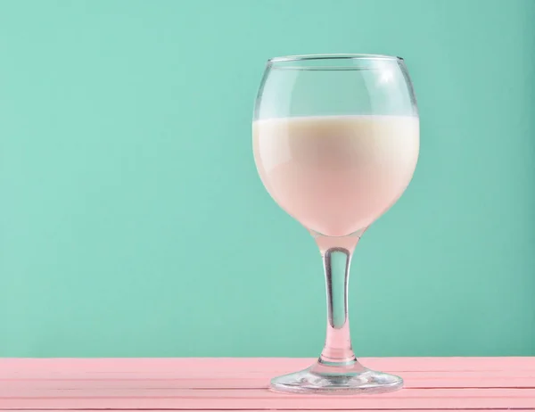 Wine glass of natural milk on a pastel background, nostalgia, minimalism trend, copy space