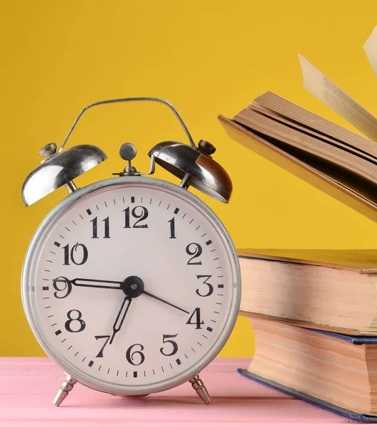 Retro Alarm Clock Books Pink Table Yellow Wall Backgroun — Stock Photo, Image