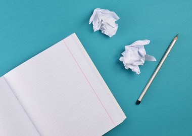 Mavi arka plan üzerinde üstten görünüm defter kalem ve beyaz buruşuk Kağıt topu ile. Hiçbir fikir, eğitim, mimari konsepti