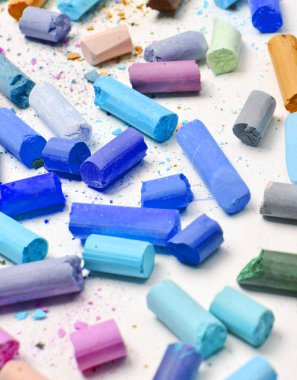 Beyaz bir arka plan üzerinde birçok çok renkli pastel boya kalemi