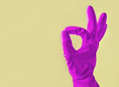 Sarı lastik eldiven el başparmak sembolü üzerinde mavi arka plan iyi gösterir. Kopya girintili