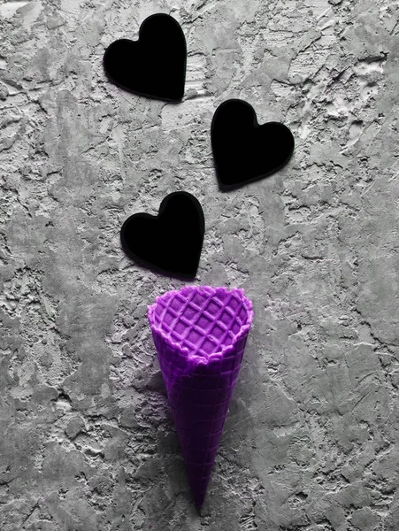Empty Violet Waffle Horn Black Hearts Gray Concrete Background Minimalist — Stock Photo, Image
