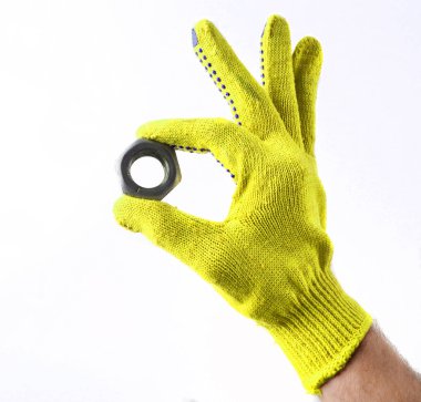 Metal bir somun çalışma eldivenli elini tutar