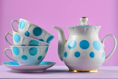 Seramik Çaydanlık, bardak lekeli mavi bir pastel arka plan üzerinde izole ahşap bir masa üzerinde bir yığın. Kopya girintili