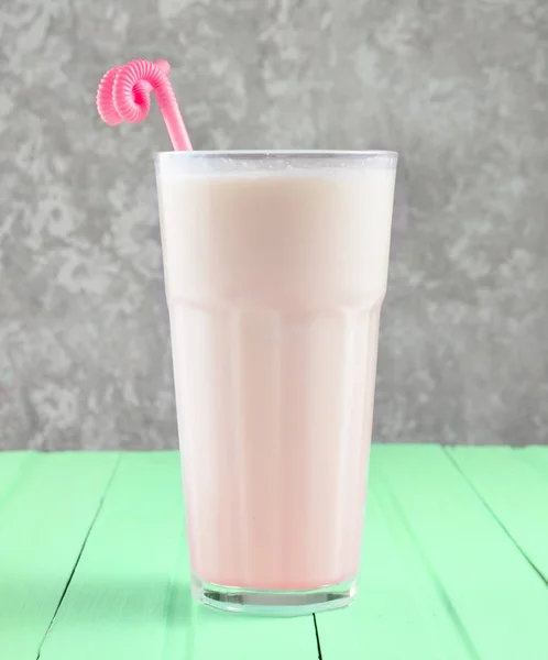 Ein Glas Milchshake Mit Einem Strohhalm Auf Einem Pastellfarbenen Holztisch — Stockfoto