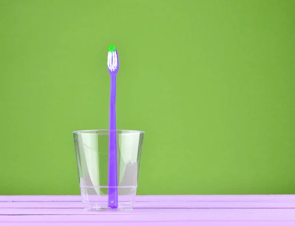 Cepillo Dientes Rosa Una Taza Transparente Sobre Fondo Verde Pastel — Foto de Stock