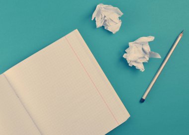 Mavi arka plan üzerinde üstten görünüm defter kalem ve beyaz buruşuk Kağıt topu ile. Hiçbir fikir, eğitim, mimari konsepti