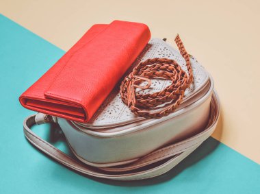 Kadın eğilim aksesuarları mavi pastel sarı bir arka plan üzerinde. Deri çanta, kırmızı çanta, kemer örgülü.