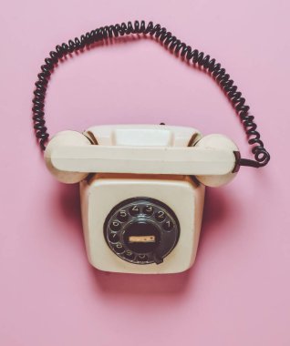Pastel pembe bir arka plan üzerinde döner retro telefon. Hattı. Yardım hattı. Üstten görünüm.