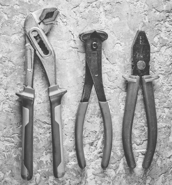 Kerpetenler, ayarlanabilir anahtarı, pense gri beton zemin üzerine. Üstten görünüm.