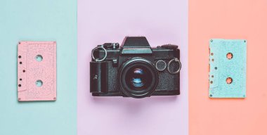 Bir retro ses Kaset kaset pastel renk ve renkli kağıt arka plan üzerinde bir film kamerası. Uzay kopyalayın. Minimalist eğilim.