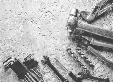 Gri beton zemin üzerine bir çalışma aracı. İngiliz anahtarları, çekiç, tornavida, pense. Üstten görünüm, kopya alanı.