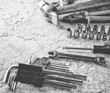 Gri beton zemin üzerine bir çalışma aracı. İngiliz anahtarları, çekiç, tornavida, pense. Üstten görünüm, kopya alanı.