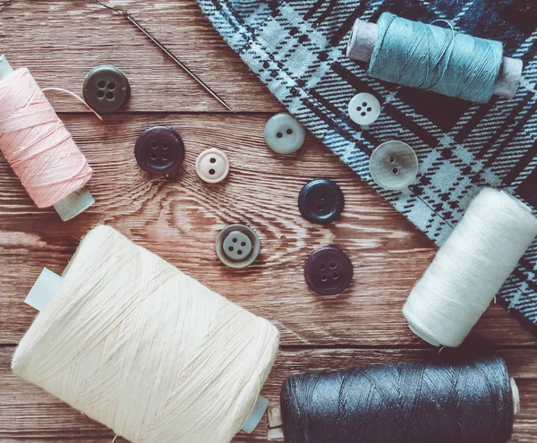 有色の糸 ボタン 木製のテーブルの針 縫製のオブジェクト トップ ビュー — ストック写真