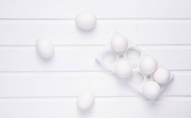 Beyaz ahşap bir masa minimalizm eğilim, üzerinde beyaz yumurta ile plastik tepsi top vie
