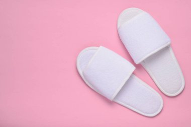 Pastel pembe arka plan, üstten görünüm, minimalist tren beyaz otel için terlikler