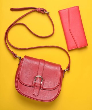 Kadın kırmızı deri çanta ve cüzdan pastel sarı bir arka plan, Bayan aksesuarlar, üstten görünüm, minimalis