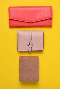 Bayan deri cüzdan pastel sarı bir arka plan, Bayan aksesuarlar, üstten görünüm, minimalis çeşitli