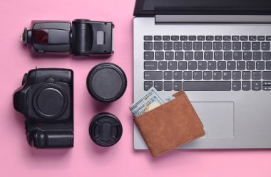 Ekipman fotoğrafçı, dizüstü bilgisayar, çanta bir pastel pembe dolar ile. Serbest kavramı, fotoğrafçının çalışmaları, nesneleri, üstten görünüm, düz la
