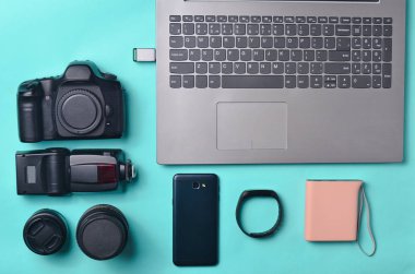 Ekipman fotoğrafçı, dizüstü bilgisayar, akıllı telefon, akıllı izlemek, mavi bir arka plan üzerinde güç banka. Serbest kavramı, iş, düz la nesneleri, en iyi görünüm için gadgets