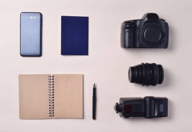 Foto muhabiri. Smartphone, defter, pasaport, kamera. Seyahat kavramı, üstten görünüm, düz la