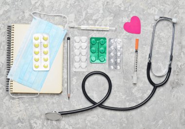 Tıbbi Kardiyoloji ekipmanları gri beton zemin üzerine. Stetoskop, tablet, termometre, Not defteri. Tıbbi kavramı, üstten görünüm, düz yatıyordu styl