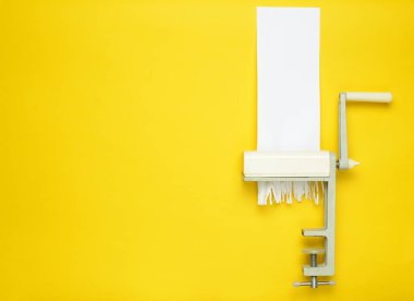 Kağıt kesme makarna bir sarı pastel arka plan, minimalist eğilim, retro tarzı için el ile bir makine tarafından kesme, top vie