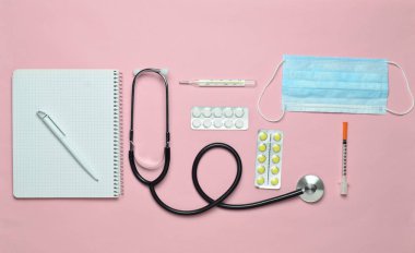 Tıbbi ekipman üzerinde bir pastel pembe. Kabarcıklar hapları, Not defteri, stetoskop, termometre, manometre. Tıbbi kavramı, üstten görünüm, düz yatıyordu styl