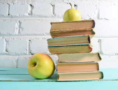 Eski kitaplar, beyaz tuğla duvar arka plan üzerinde elma yığını. Okul kavramı, eğitim