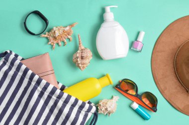 Plaj çantası ve aksesuarları pastel mavi arka plan üzerinde plaj düzendeki rahatlamak için. Deniz, yaz saati Resort'ta kavramı. Üstten görünüm, düz yatıyordu, minimalis