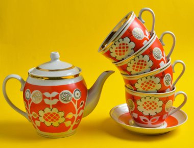 Retro bardak ve çaydanlık sarı bir arka plan üzerine yığını
