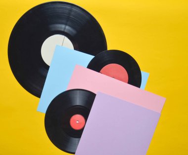 Pastel renkli bir arka plan üzerinde vinil tabaklar. Retro müzik öznitelikleri 80s. üstten görünüm, Minimalizm. Kopya girintili