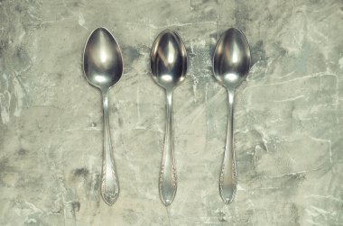 Vintage Çelik kaşık üzerinde gri bir arka plan beton. Top Vie