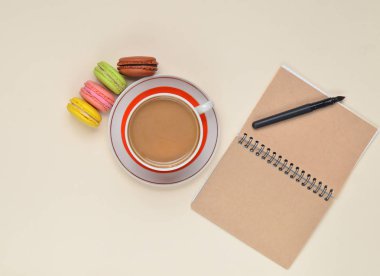 Fincan kahve, renkli macaroons, beyaz zemin üzerine kalem ile not etmek
