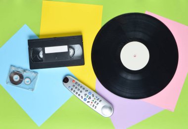 Vinil plak, tv uzaktan, ses kaset, video kaset çok renkli kağıt arka plan üzerinde. Retro tarzı. top vie