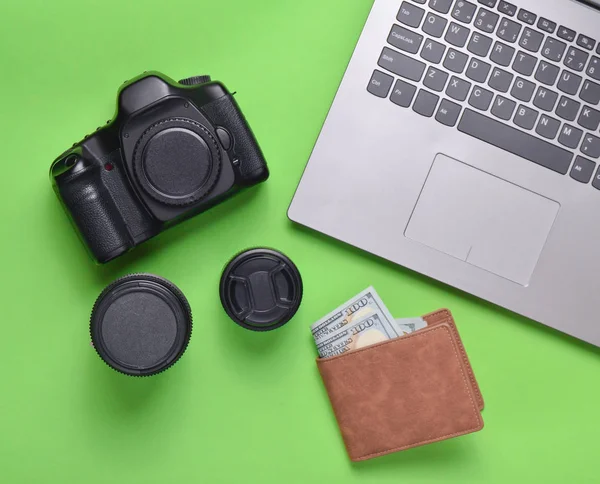 Ekipman fotoğrafçı, dizüstü bilgisayar, çanta dolar üzerinde yeşil bir arka plan ile. Serbest kavramı, fotoğrafçının çalışmaları, nesneleri, üstten görünüm, düz la