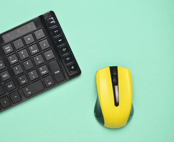 Wireless mouse and keyboard isolated on blue pastel background. Top view, minimalist tren