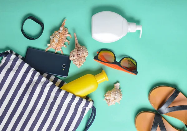 Plaj çantası ve aksesuarları pastel mavi arka plan üzerinde plaj düzendeki rahatlamak için. Deniz, yaz saati Resort'ta kavramı. Üstten görünüm, düz yatıyordu, minimalis