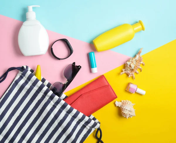 Plaj çantası ve aksesuarları pastel renkli arka plan üzerinde plaj düzendeki rahatlamak için. Deniz, yaz saati Resort'ta kavramı. Üstten görünüm, düz yatıyordu, minimalis