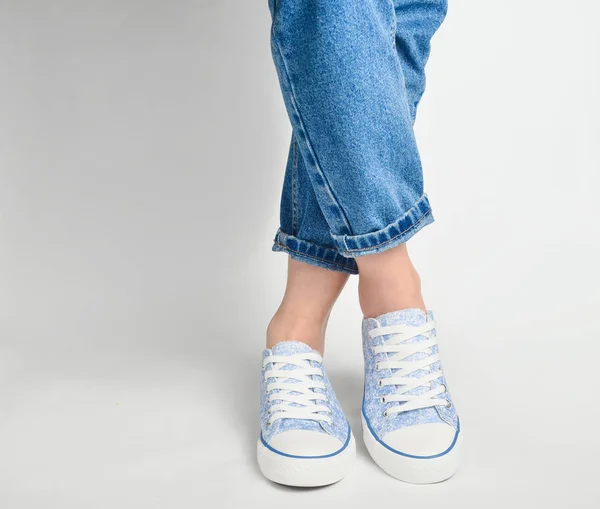 Gambe Femminili Jeans Corti Sneakers Poggiano Uno Schienale Bianco — Foto Stock