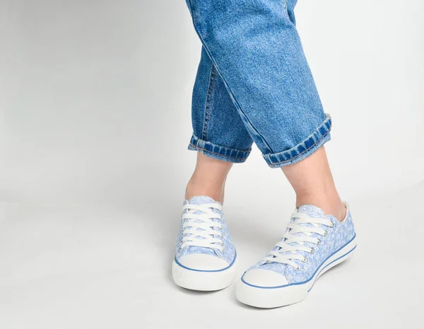 Gambe Femminili Jeans Corti Sneakers Poggiano Uno Schienale Bianco — Foto Stock