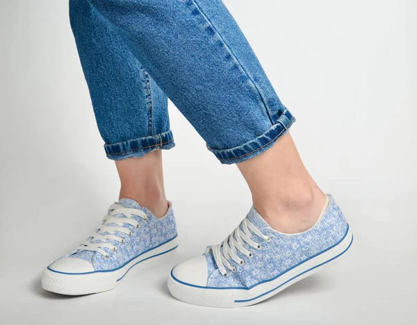 Γυναικεία Πόδια Σύντομο Τζιν Και Sneakers Σταθεί Ένα Λευκό Backgroun — Φωτογραφία Αρχείου