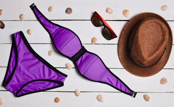 Mayo, şapka, güneş gözlüğü, deniz kabuklarını bir beyaz tahta yüzey üzerinde. Plaj sezonu için hazırlanıyor. Yaz saati. Üstten görünüm.